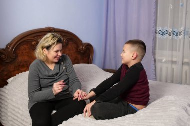 Anne oğlunun tırnaklarını kesti. Anne bakımı..