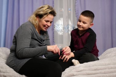 Anne oğlunun tırnaklarını kesti. Anne bakımı..