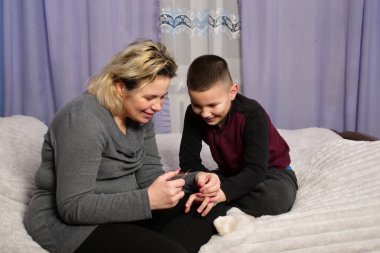 Anne oğlunun tırnaklarını kesti. Anne bakımı..