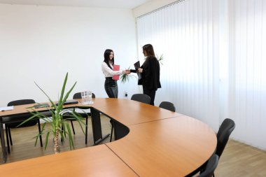 İki kız iş konuşmak ve kontrat imzalamak için ofiste buluşuyor..