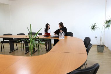 İki kız iş konuşmak ve kontrat imzalamak için ofiste buluşuyor..