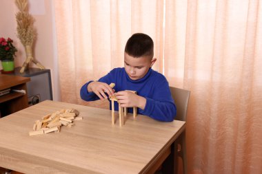 Çocuk tahta küplerden piramitler inşa ediyor. Boş zamanlarınızda masa oyunları.