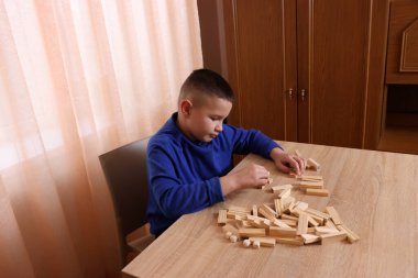 Çocuk tahta küplerden piramitler inşa ediyor. Boş zamanlarınızda masa oyunları.