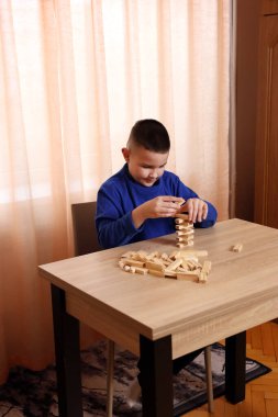 Çocuk tahta küplerden piramitler inşa ediyor. Boş zamanlarınızda masa oyunları.