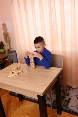 Çocuk tahta küplerden piramitler inşa ediyor. Boş zamanlarınızda masa oyunları.