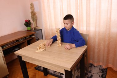 Çocuk tahta küplerden piramitler inşa ediyor. Boş zamanlarınızda masa oyunları.