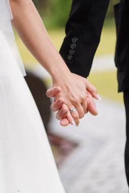 Yeni evliler el ele tutuşuyor. Düğün töreni..