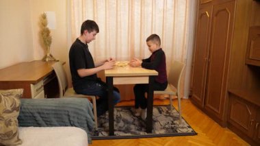 İki çocuk tahta bloklardan piramit inşa etmek için masa oyunu oynuyorlar..