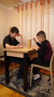 İki çocuk tahta bloklardan piramit inşa etmek için masa oyunu oynuyorlar..