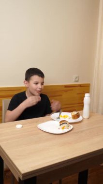 Bir adam masada otururken hamur işi yer, çay içer ve yoğurt içer..