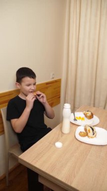 Bir adam masada otururken hamur işi yer, çay içer ve yoğurt içer..