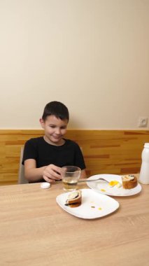 Bir adam masada otururken hamur işi yer, çay içer ve yoğurt içer..