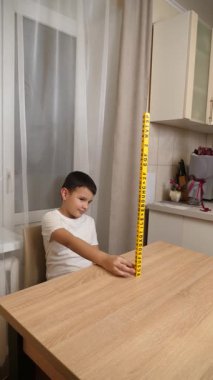 Bir çocuk masada otururken küplerden kelimeler üretiyor..