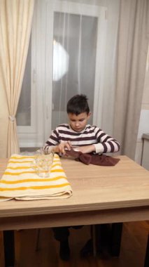 Oğlan bardakları ve bardakları havluyla siler. Ev işleri..