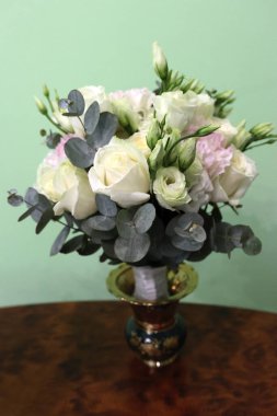 Masadaki vazoda bir buket beyaz gül..