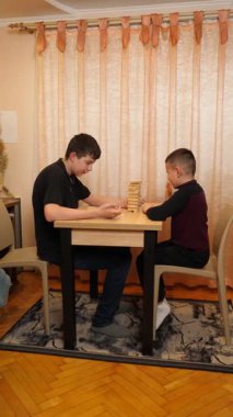 İki çocuk tahta bloklardan piramit inşa etmek için masa oyunu oynuyorlar..