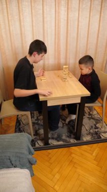 İki çocuk tahta bloklardan piramit inşa etmek için masa oyunu oynuyorlar..