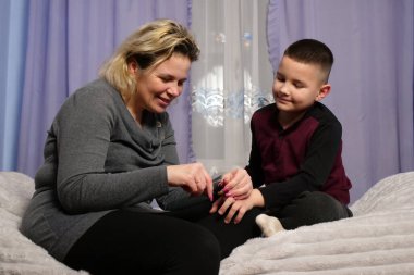 Anne oğlunun tırnaklarını kesti. Anne bakımı..