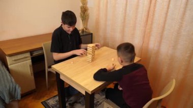 İki çocuk tahta bloklardan piramit inşa etmek için masa oyunu oynuyorlar..