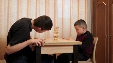 İki çocuk tahta bloklardan piramit inşa etmek için masa oyunu oynuyorlar..