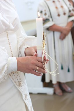 Gelin, düğün sırasında elinde yanan bir mum tutuyor..