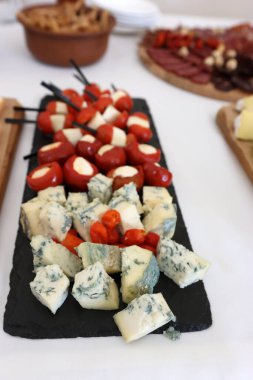 Kutlama masasında çeşitli peynir ve soslarla dolu bir tabak..