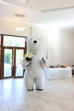 Bir buket çiçekli beyaz panda kostümlü bir adam arkadaşlarıyla bir partiye geldi..