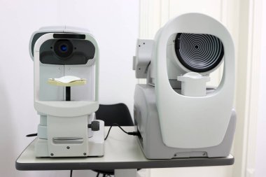 Göz altı tanı cihazları: temas olmayan tonometre ve kornea topografı yan yana. Göz bakımı kliniklerinde göz basıncını ölçmek ve kornea şeklini haritalamak için kullanılır.