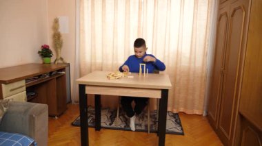 Bir çocuk tahta küplerle oynar, farklı şekiller oluşturur..