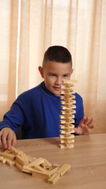 Bir çocuk tahta küplerle oynar, farklı şekiller oluşturur..