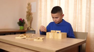 Çocuk tahta parçaları birleştirerek Jenga oyunu oynuyor.