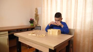 Çocuk tahta parçaları birleştirerek Jenga oyunu oynuyor.