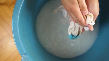 Beyaz çorapları havuzda elle yıkayan bir adam. Ev işleri..