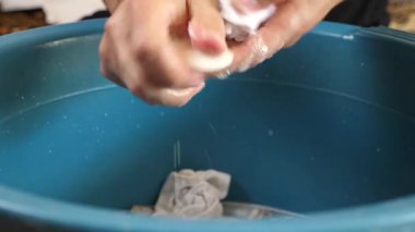 Beyaz çorapları havuzda elle yıkayan bir adam. Ev işleri..