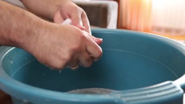 Beyaz çorapları havuzda elle yıkayan bir adam. Ev işleri..