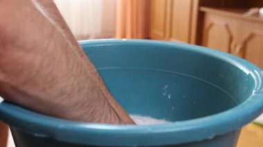 Beyaz çorapları havuzda elle yıkayan bir adam. Ev işleri..