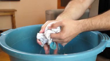 Beyaz çorapları havuzda elle yıkayan bir adam. Ev işleri..