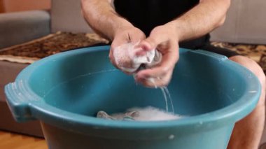 Beyaz çorapları havuzda elle yıkayan bir adam. Ev işleri..