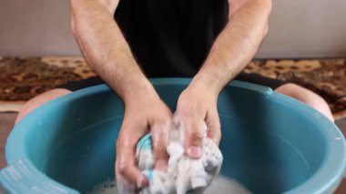 Beyaz çorapları havuzda elle yıkayan bir adam. Ev işleri..