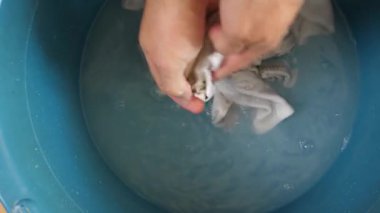 Beyaz çorapları havuzda elle yıkayan bir adam. Ev işleri..