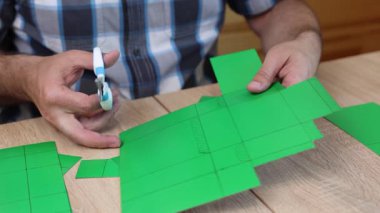 Çizgili şablon çizgileri boyunca renkli karton kesme, DIY yaratıcı proje için kağıt model parçaları el yapımı.