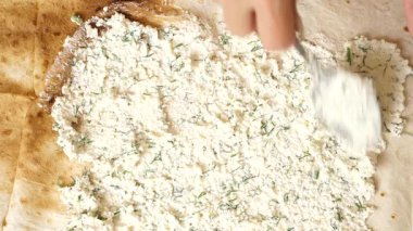 Peynir karışımını rulo pide ekmeğine sürüyorum. Pita tabağı hazırlıyorum..