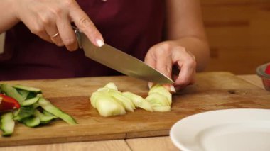 Salatalık bıçakla parçalara ayrılır. Sebzelerden yemek pişirme.