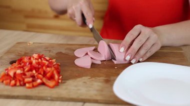 Haşlanmış sosisi küp küp doğra. Olivier salatasını hazırla..