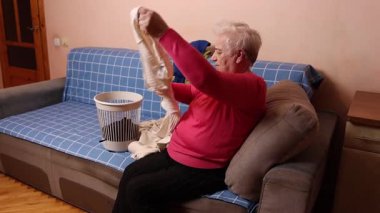 Büyükanne çamaşır katlar, kuruttuktan sonra kazak serer. Ev işi süreci ve temizlik işleri..