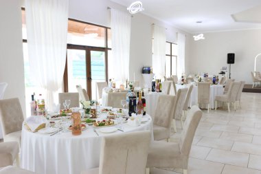 Yemek ve içeceklerle dolu masalarla dolu bir festival salonu..