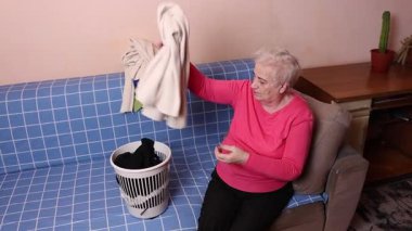 Büyükanne çamaşır katlar, kuruttuktan sonra kazak serer. Ev işi süreci ve temizlik işleri..