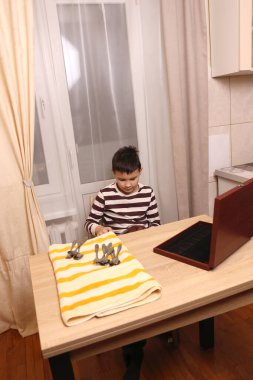 Oğlan çatal ve mutfak bıçaklarını siliyor. Ev işleri..