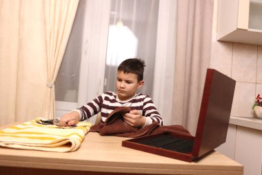 Oğlan çatal ve mutfak bıçaklarını siliyor. Ev işleri..