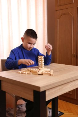 Çocuk tahta küplerden piramitler inşa ediyor. Boş zamanlarınızda masa oyunları.